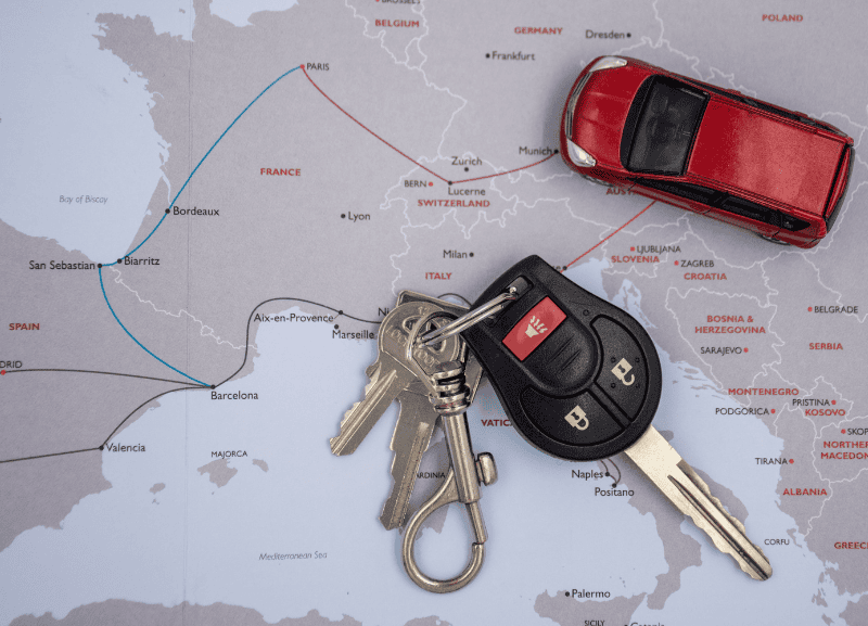 Chiavi di auto e modellino su mappa Europa, nozioni di noleggio veicoli.