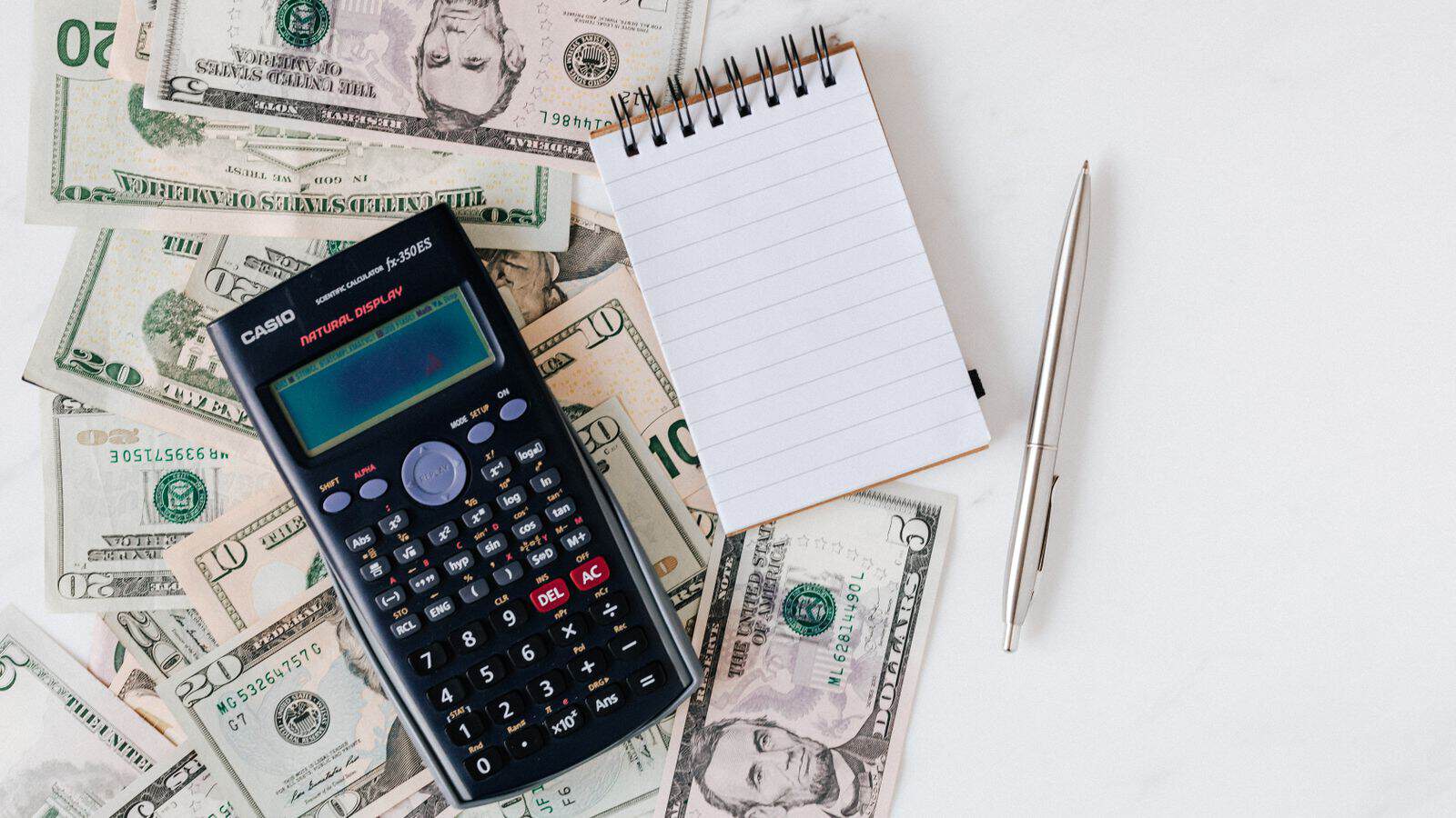 Calculator and rental bills on a desk representing a Las Vegas rent increase decision