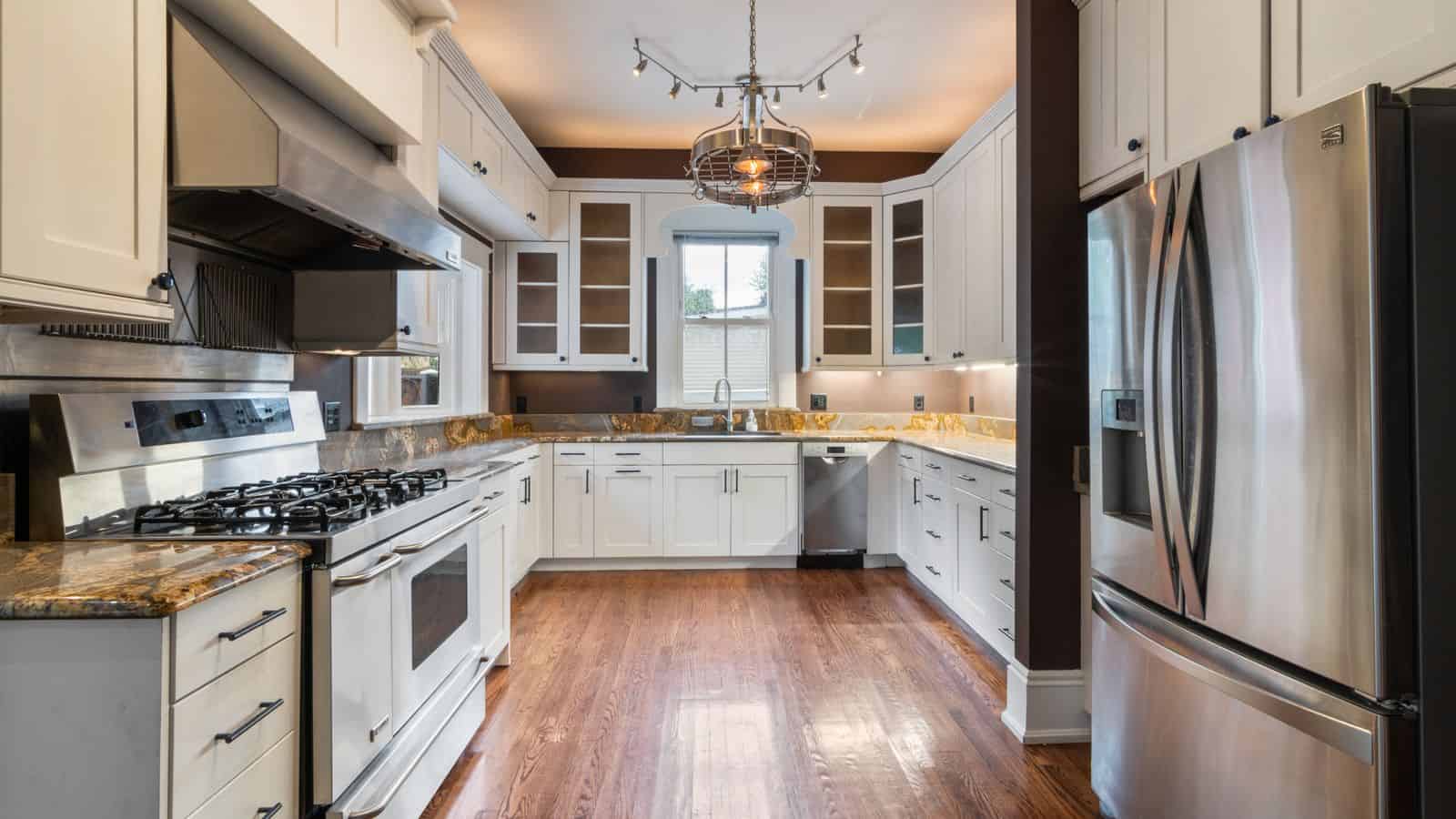 Modern rental kitchen with stainless steel refrigerator, stove, and built-in appliances