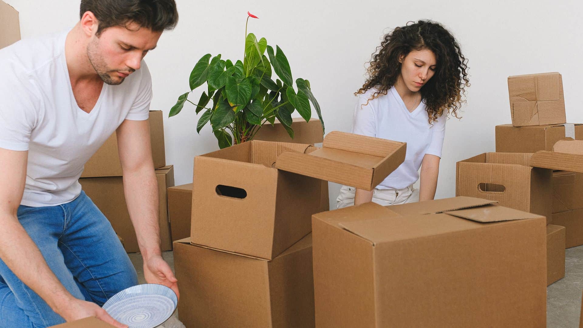 Two roommates unpacking boxes in a Las Vegas apartment after being added to the lease