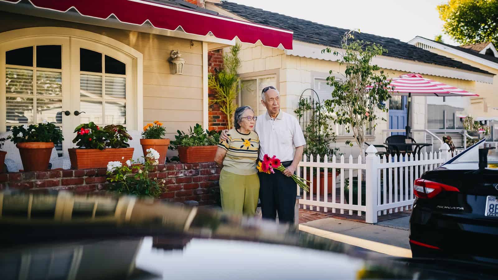 Senior couple standing in front of their home in a 55 plus active adult community in Las Vegas