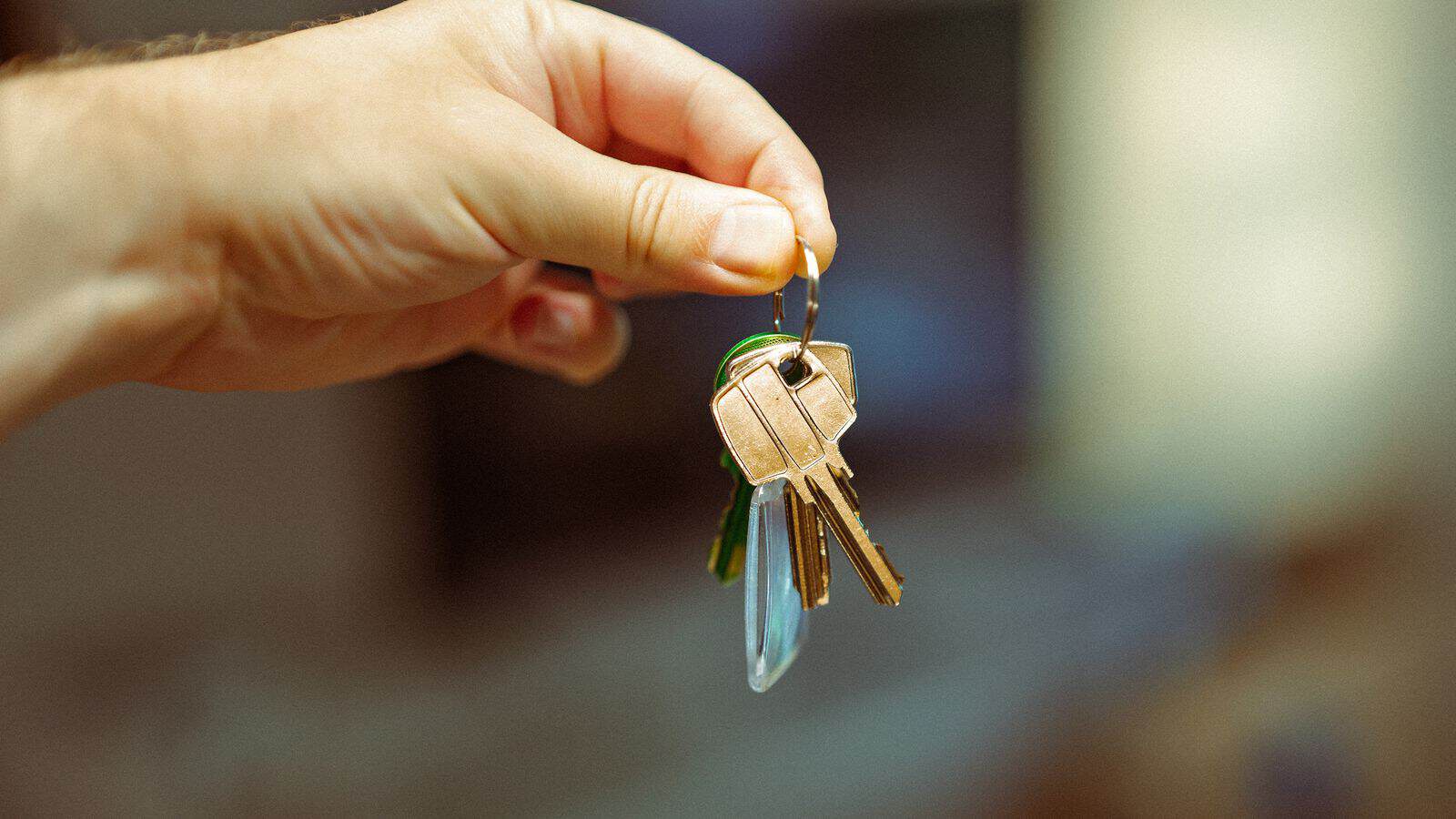 Hand holding a keyring with several house keys representing a Las Vegas rental security deposit and move-in