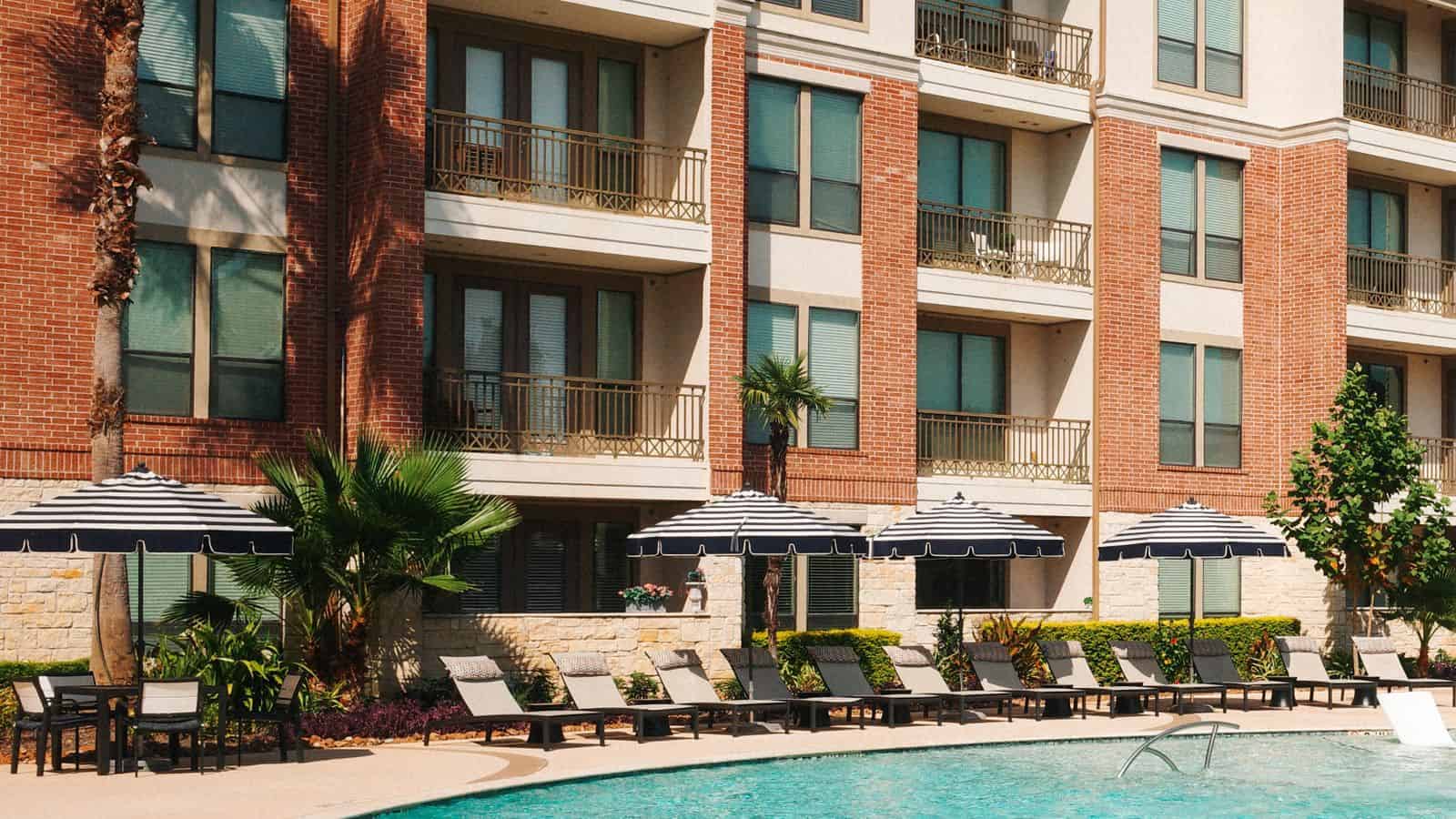 Modern apartment complex with outdoor pool and lounge chairs in a Las Vegas community