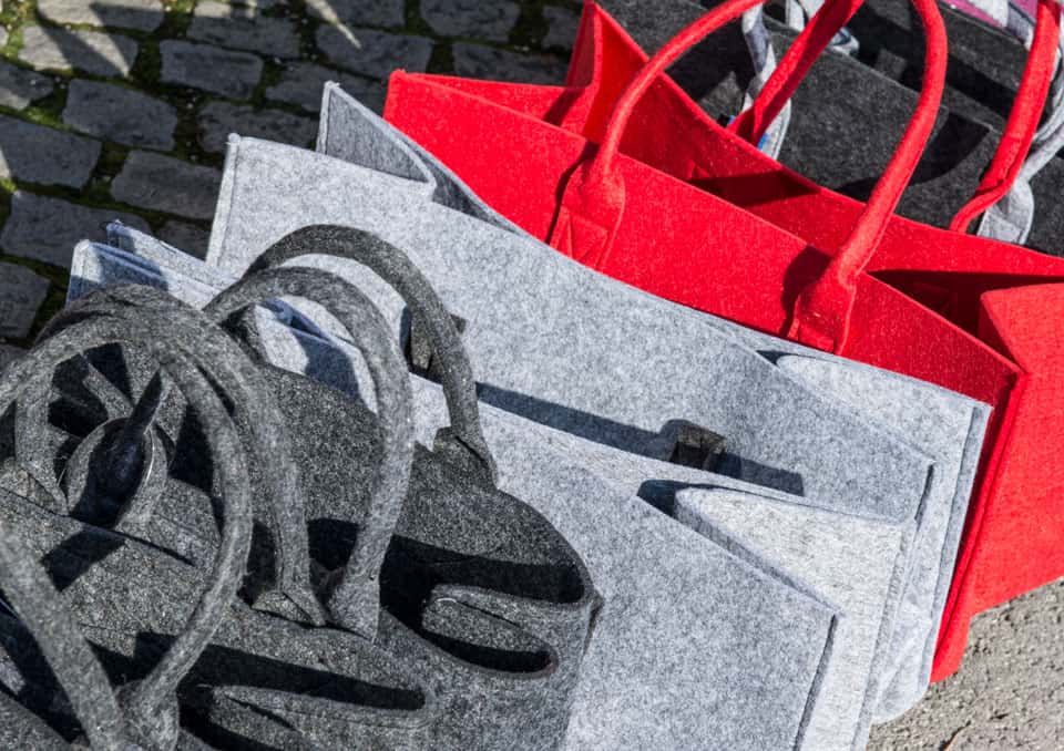 Hochwertige Natursteintaschen in verschiedenen Farben und Designs von Ischler Holzhandwerk, perfekt für nachhaltige Geschenke und Dekoration.