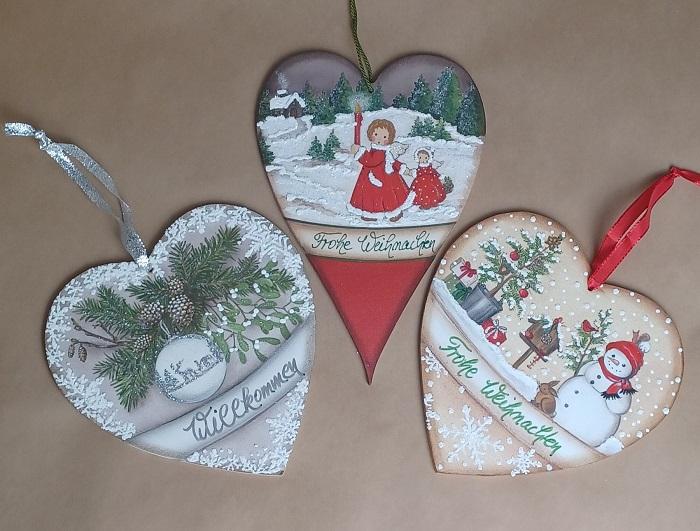 Traditionelle Weihnachtsdeko aus Holz mit winterlichen Motiven und Sprüchen für die Adventszeit.