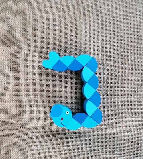 Bunter Holz-Wurm als Kinderspielzeug, handgefertigt aus Holz und liebevoll bemalt.