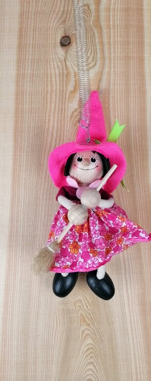 Detailreiche Holzkunstfigur mit Kleid und Hut.