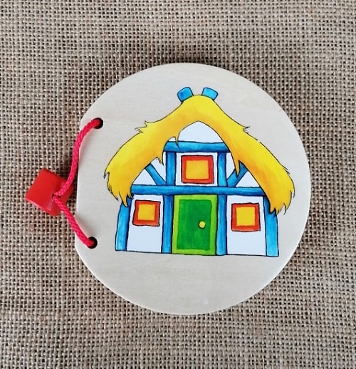 Dekoratives Holzigare-Accessoire, gefertigt aus Holz, mit buntem Hausmotiv, ideal als Geschenk.