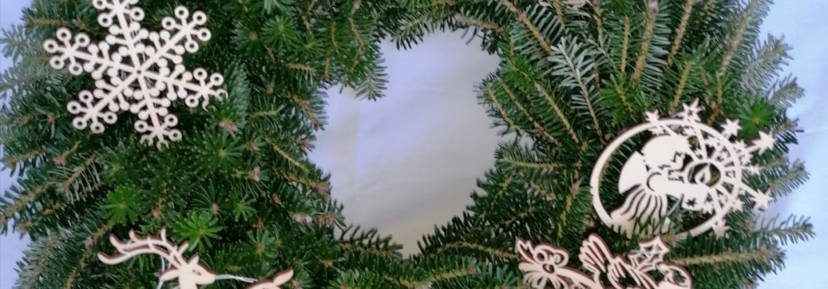 Dekorativer Weihnachtskranz aus Holz mit filigranen Holzornamenten und Tieren, handgemacht in Ischler Holzhandwerk.