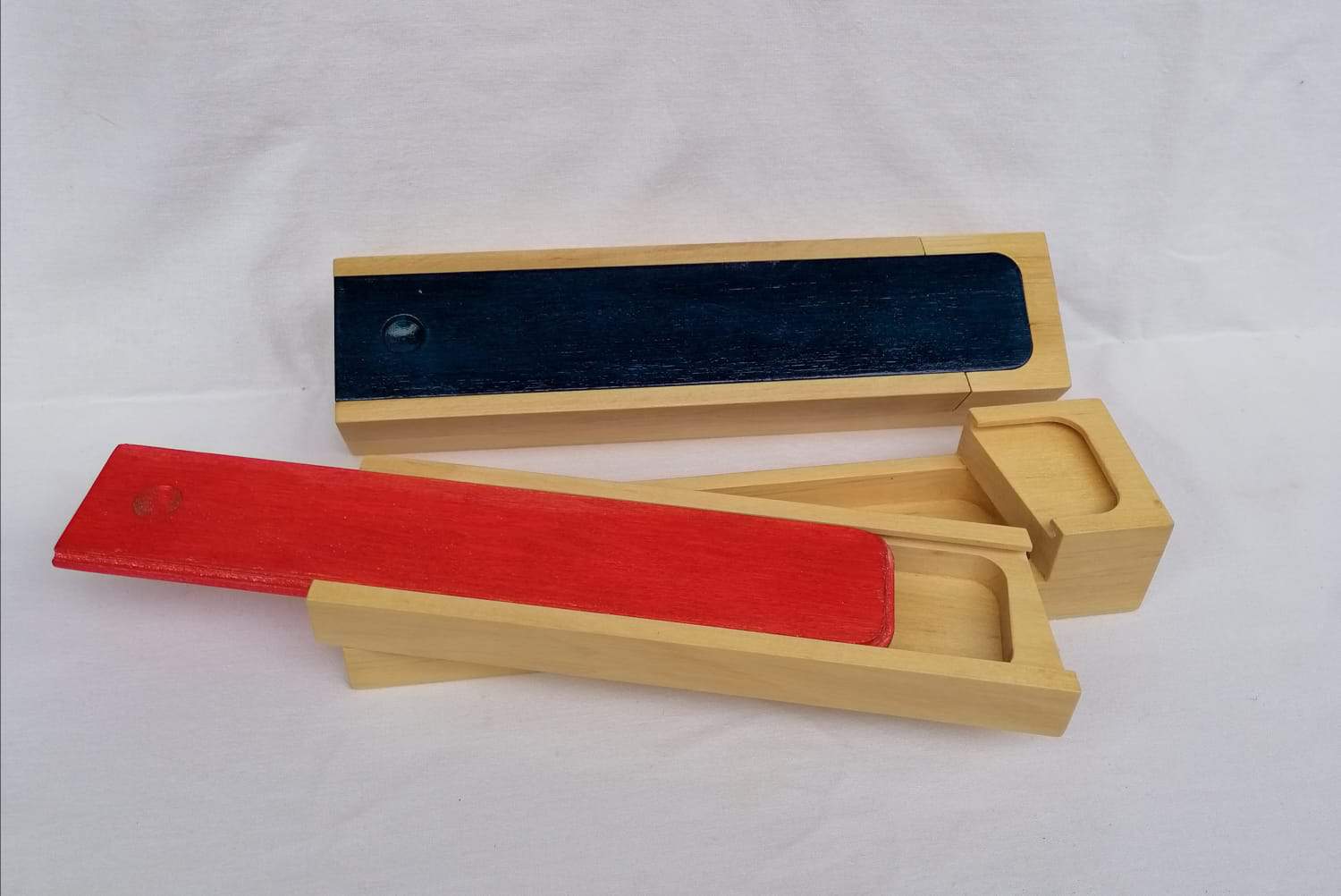 Alt: Traditionelle Holzspiele mit bunten Farben, handgefertigt in Ischler Holzhandwerk.