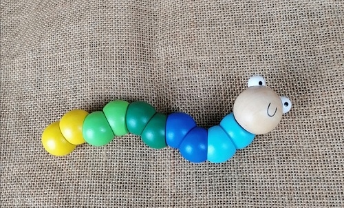 Bunte Holzlarve, handgefertigtes Holzspielzeug in verschiedenen Farben für Kinder, nachhaltiges Design, Ischler Holzhandwerk.