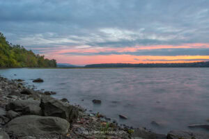 A photo looking north up the Hudson River during sunrise on a September morning from along the shoreline of Lighthouse Park.