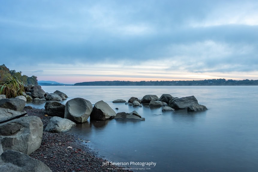 A photo of dawn breaking over the Hudson River from along the shore of Lighthouse Park.