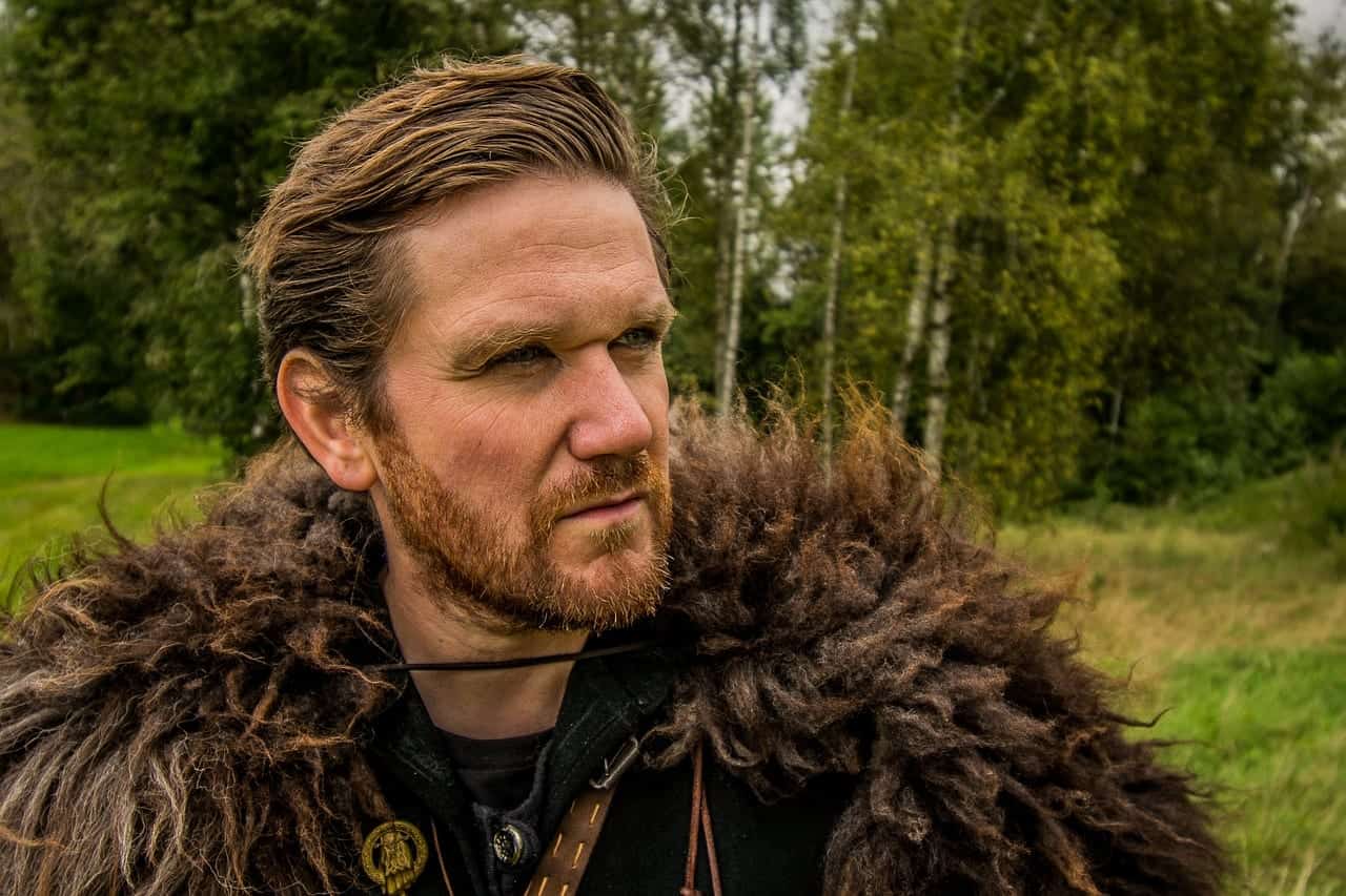 man in fur coat in forest setting