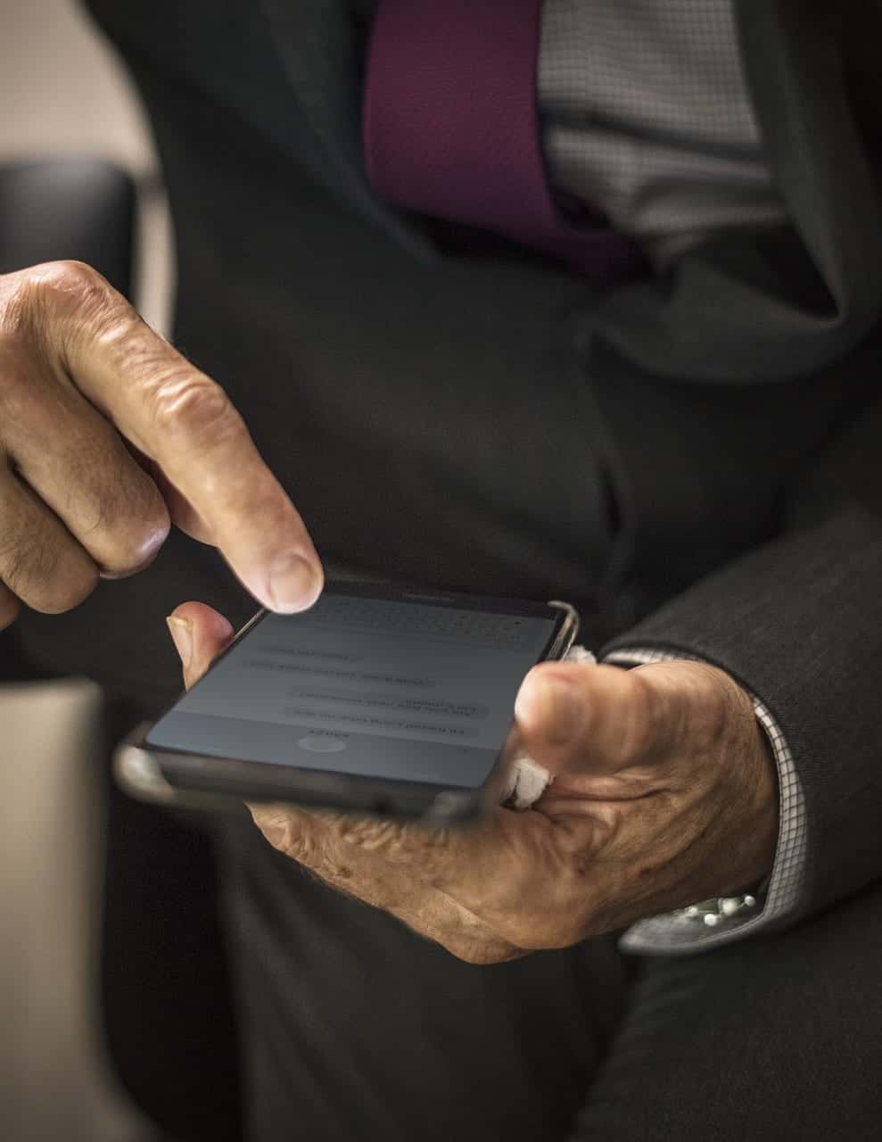 man's hand scrolling through phone