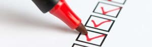Checklist with red checkmarks and a red marker for task completion.