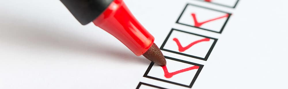 Checklist with red checkmarks and a red marker for task completion.