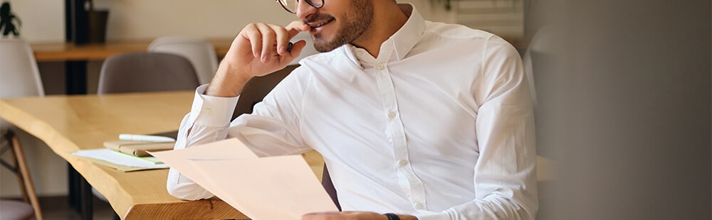 Business professional reviewing paperwork in a modern office environment.