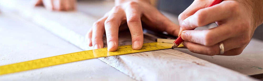 Measuring tape being used for precise measurement in a woodworking or construction project.