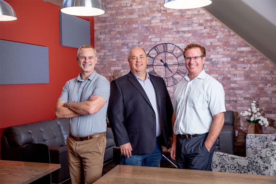 Business professionals in modern office with brick wall background.
