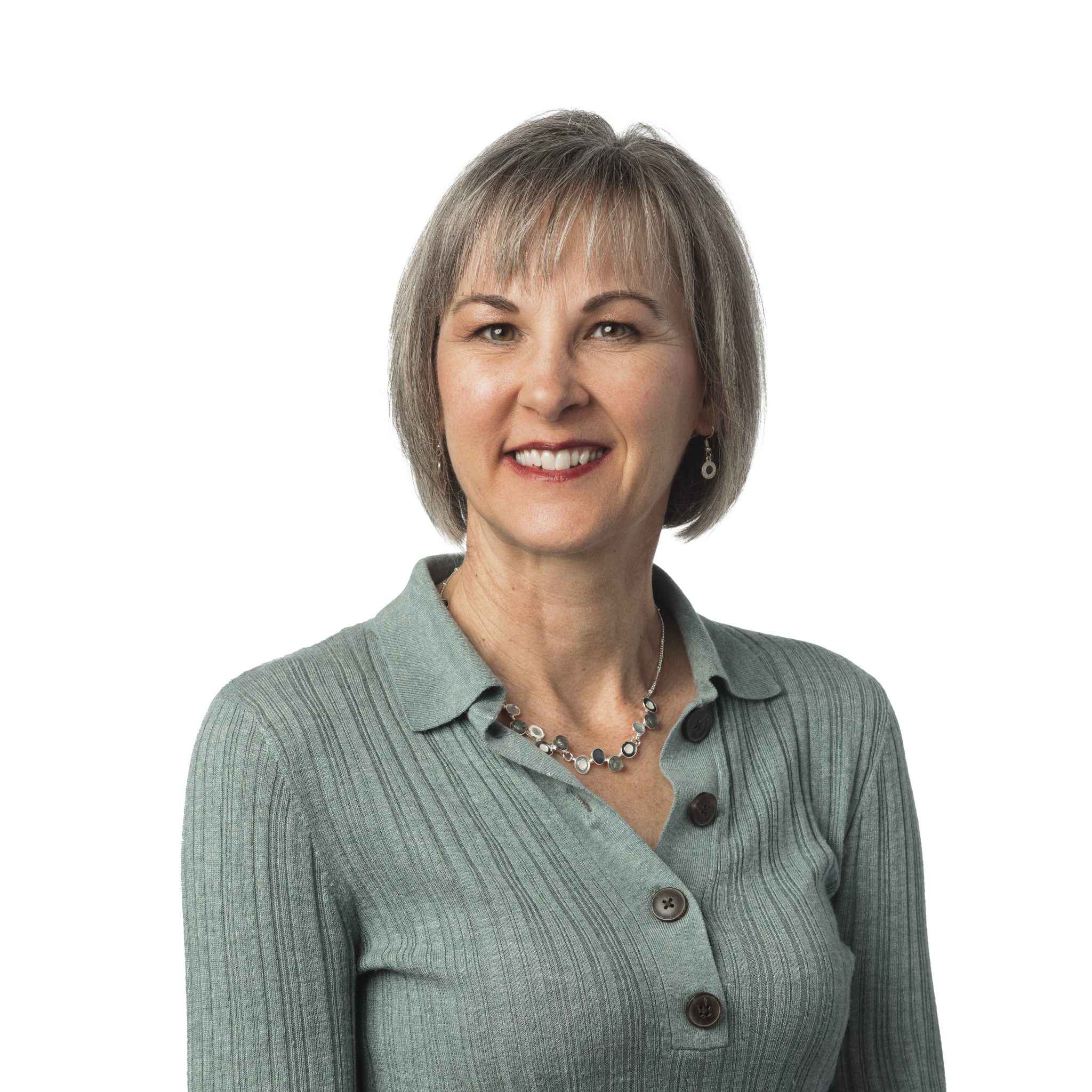 Woman smiling in a grey sweater, professional headshot.