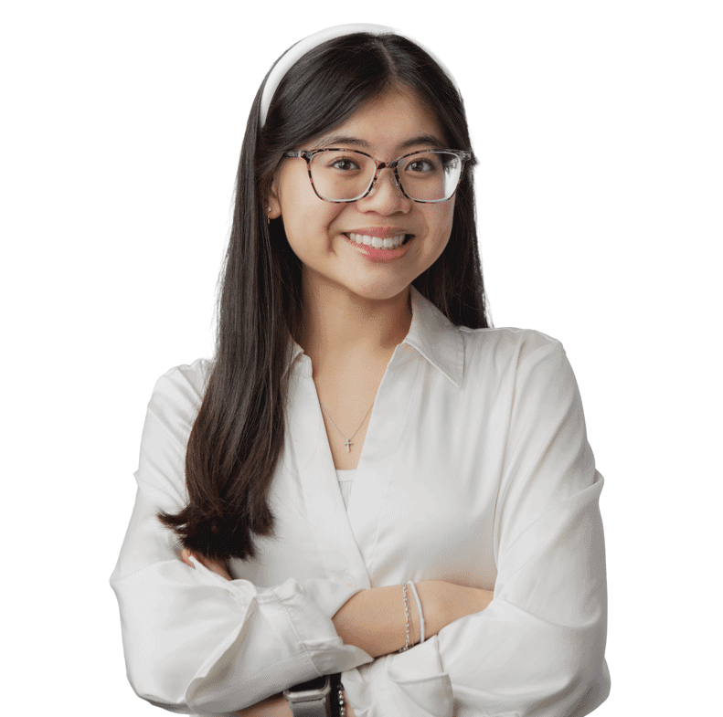 Young woman with glasses smiling confidently, wearing a white shirt and a cross necklace.