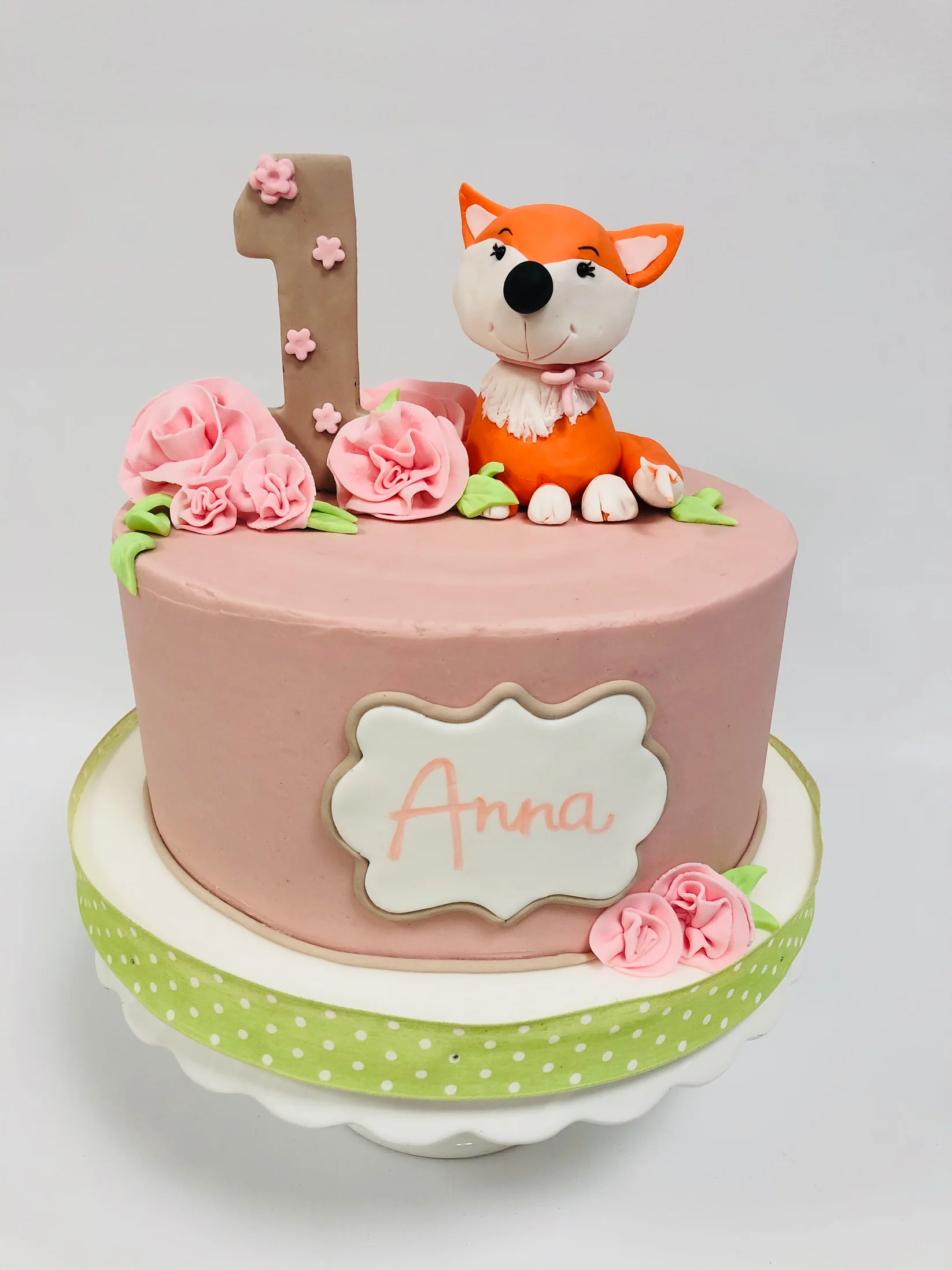 Torta di compleanno rosa con decorazione di un simpatico cane in pasta di zucchero, fiorellini rosa.