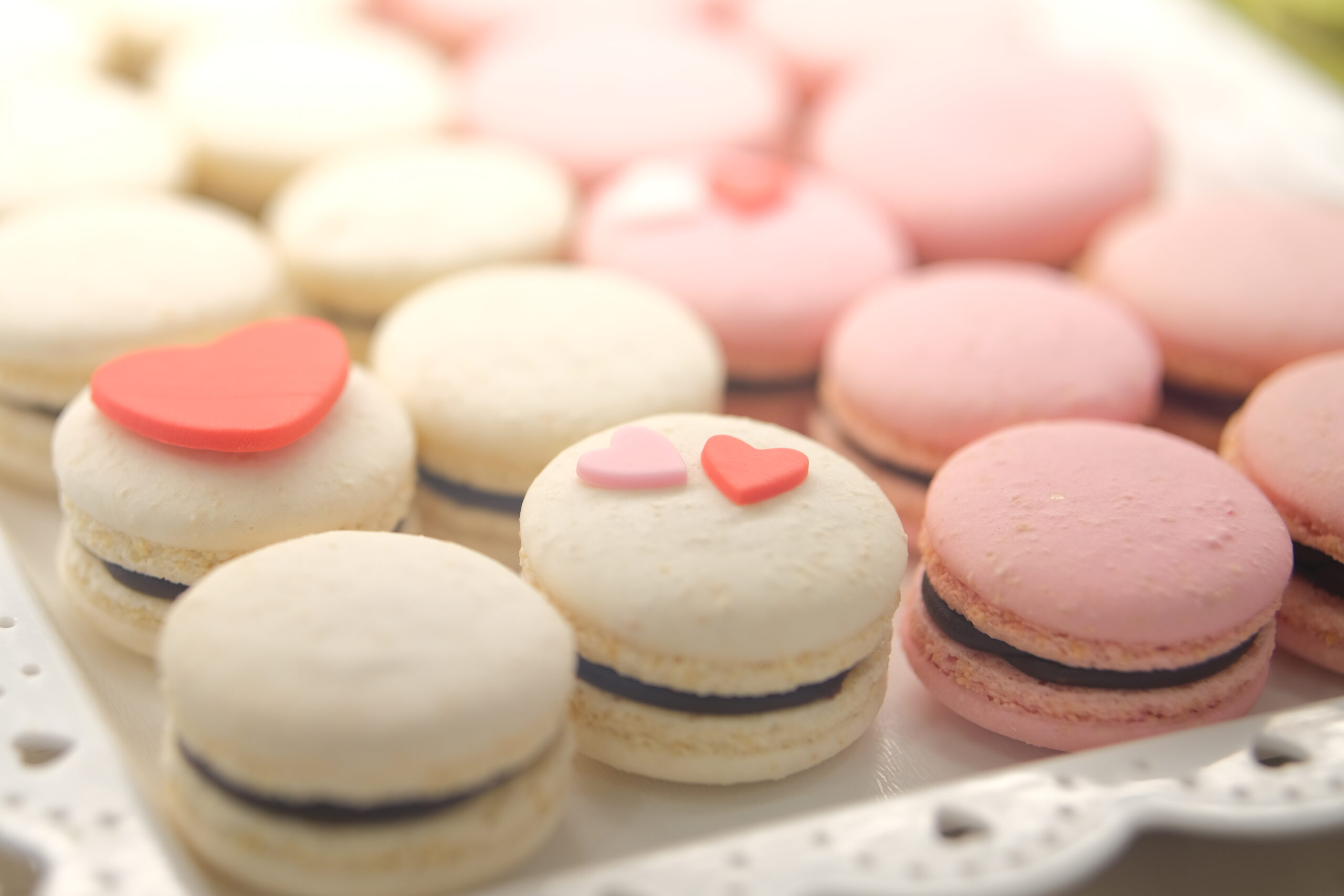 Macarons con decorazioni a forma di cuore rosa e bianco.