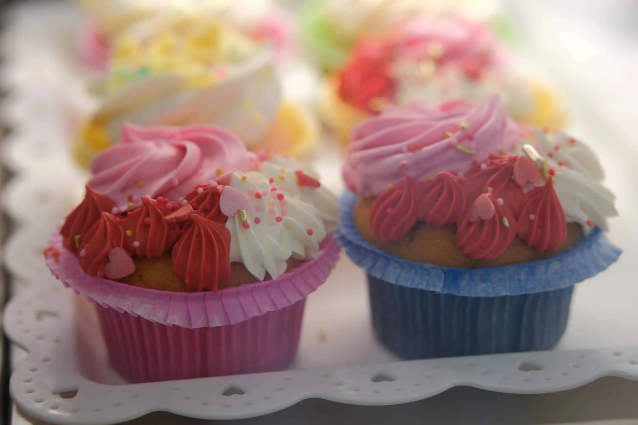 Cupcakes decorati con glassa rosa, bianca e rossa, perfetti per ogni occasione speciale.