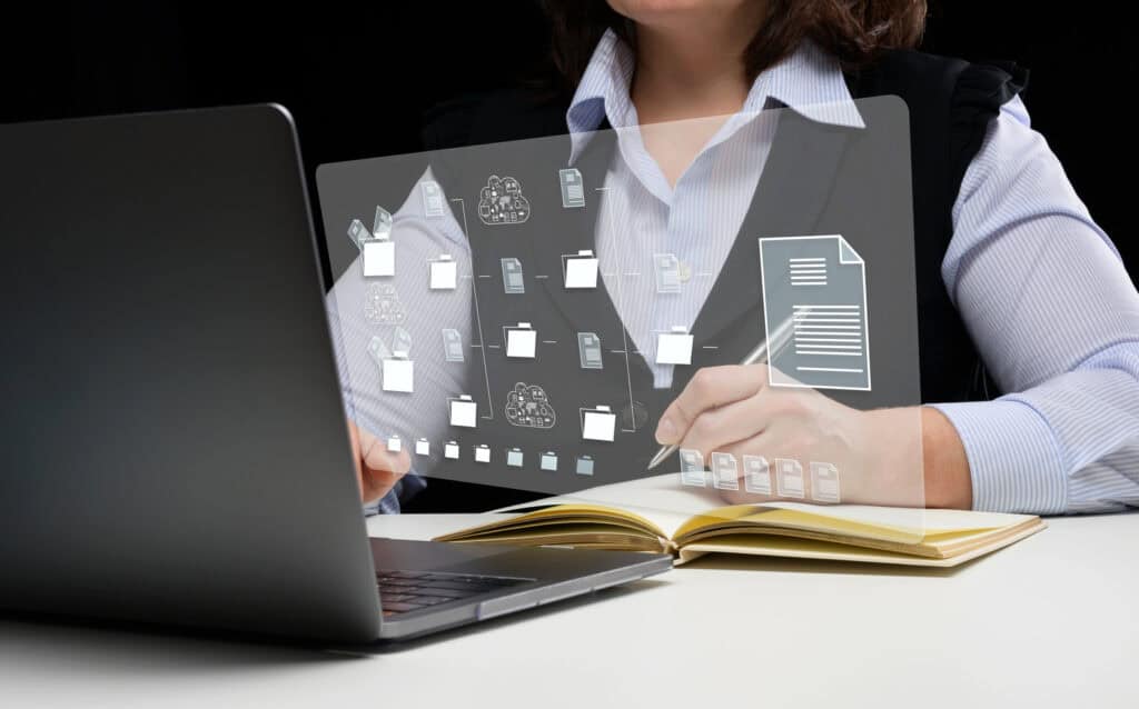 Abogada trabajando frente a un portátil con una interfaz holográfica de gestión de documentos, representando la organización eficiente con el mejor software jurídico para abogados en 2025