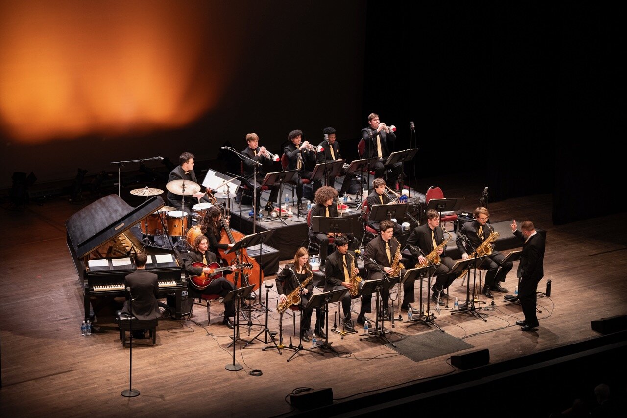 Swing jazz band performing on stage at Madison Jazz Society concert, jazz ensemble with saxophones, trumpet, drums, and piano, live jazz music event in Madison Wisconsin.