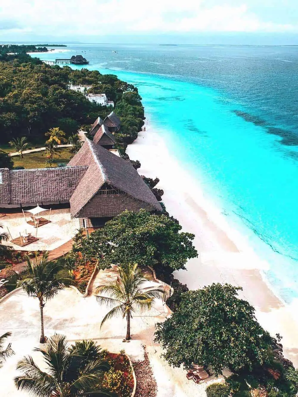 A drone view looking down on a tropical white sandy beach in Zanzibar