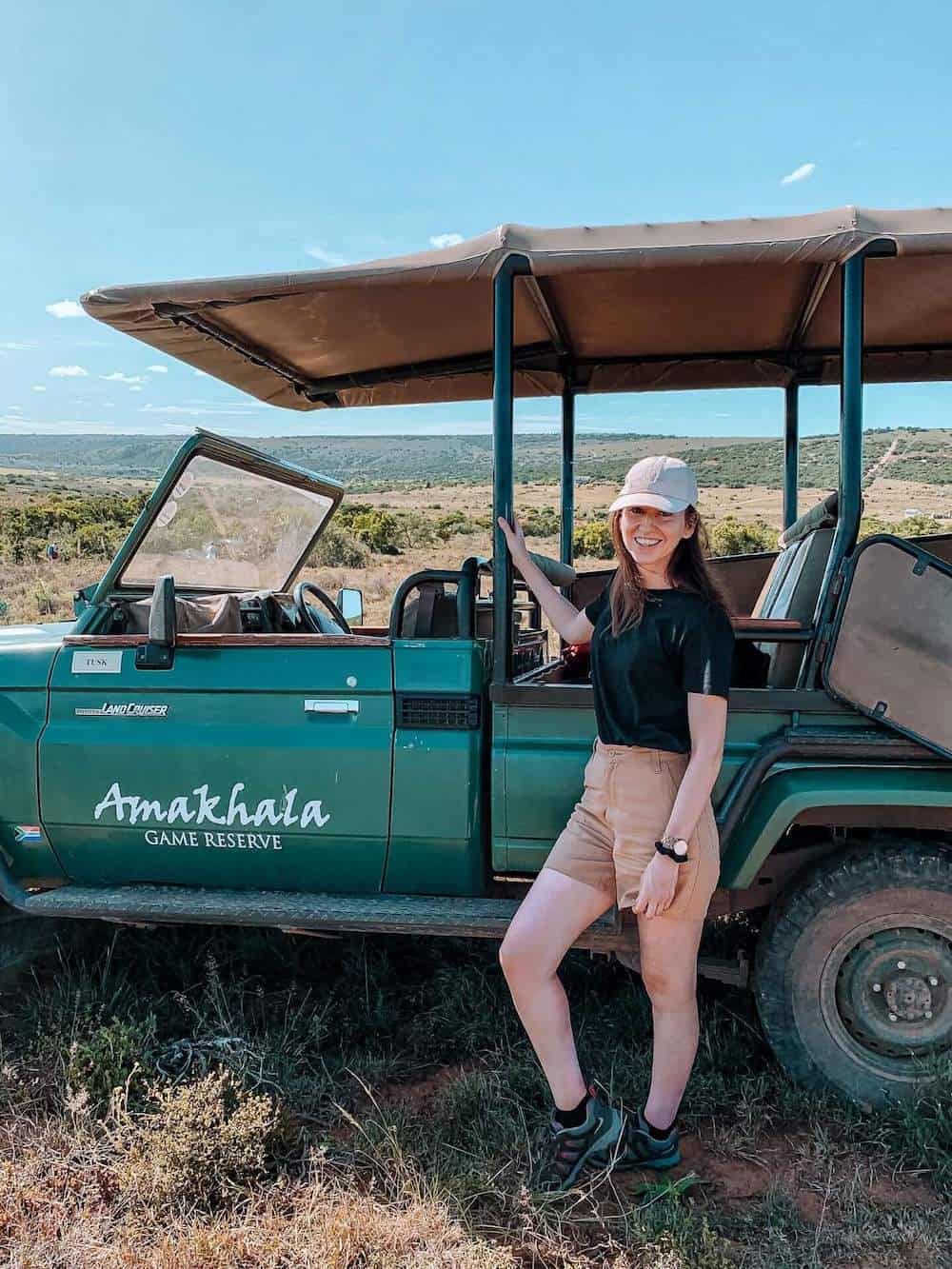 Hannah standing in front of a green safari jeep in South Africa