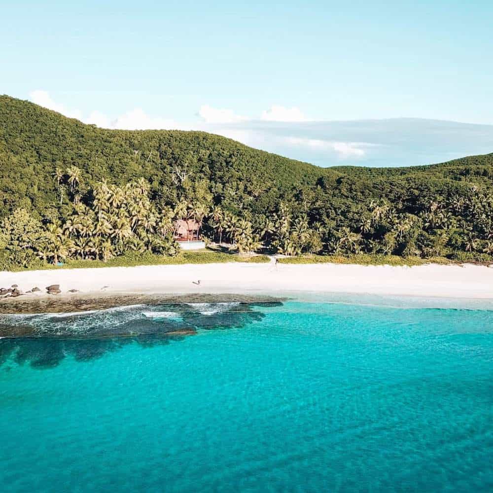 A view across turquoise sea towards a tropical white-sand island
