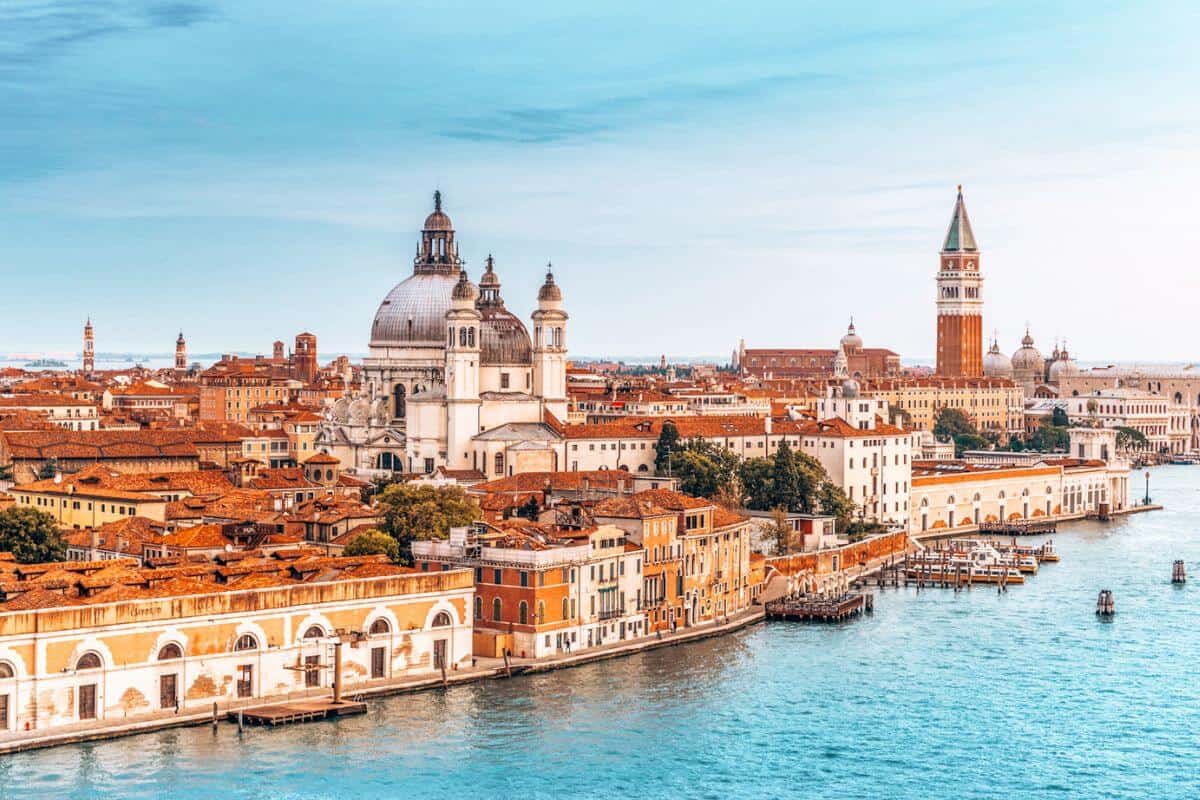 A drone view looking across the city of Venice with its golden buildings and grand canal