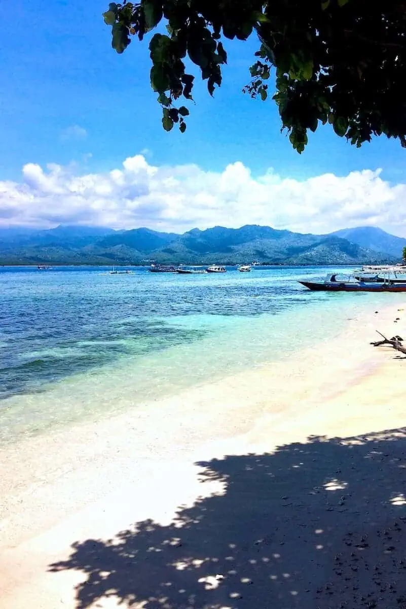 A white sandy beach with brilliant blue water in the Gili Islands