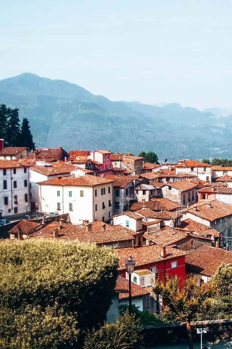 A pretty town in Italy with red roof buildings set in front of mountains