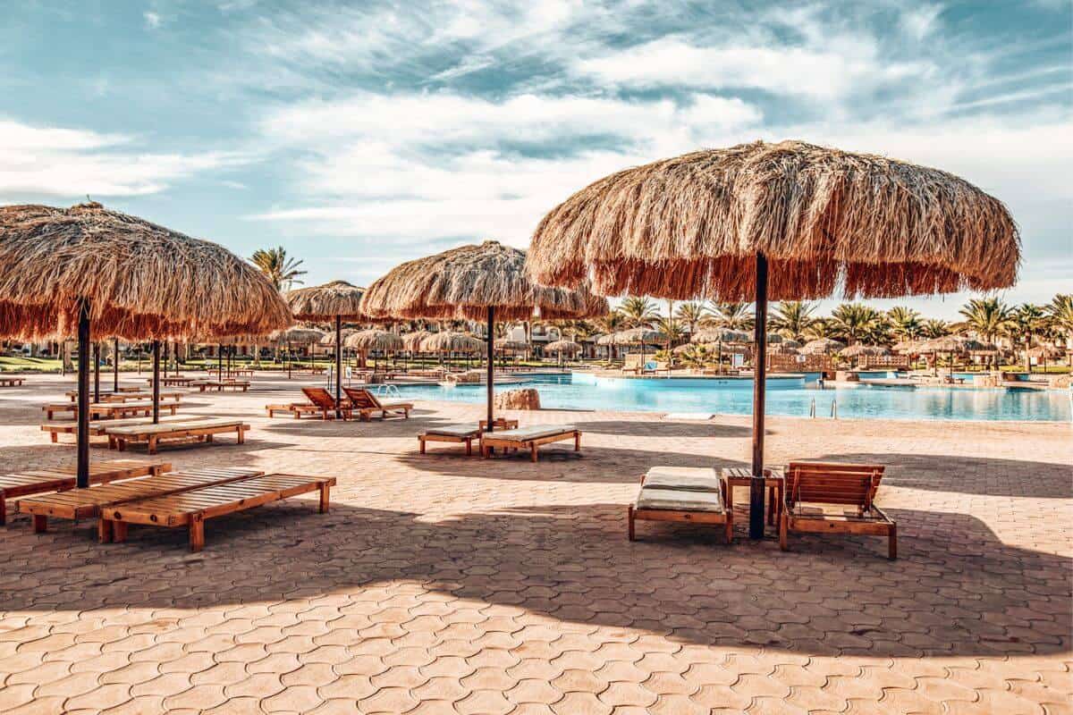 Sun loungers with traditional beach umbrellas at a luxury resort in Egypt