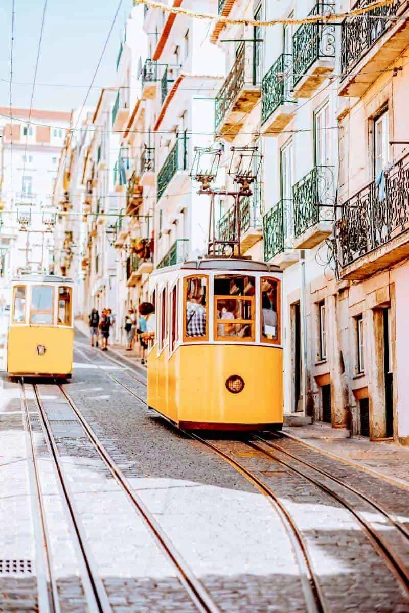 A bright yellow tram in a quaint street in Lisbon