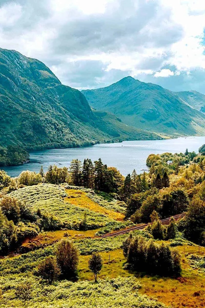 A lake surrounded by mountains and trees in Scotland