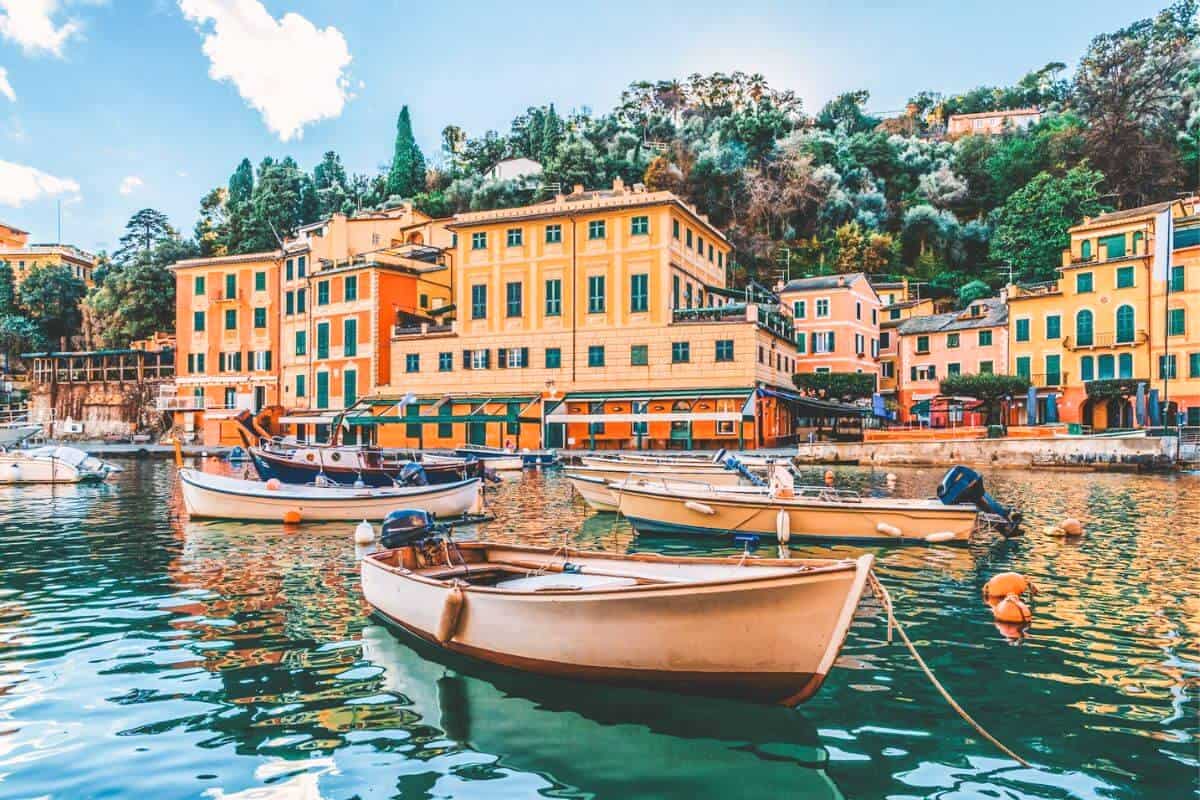 Several boats in a quaint, pastel coloured waterside area in Italy