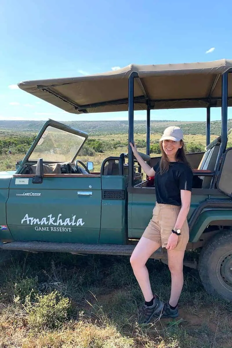 A woman (me!) standing in front of a safari jeep in South Africa