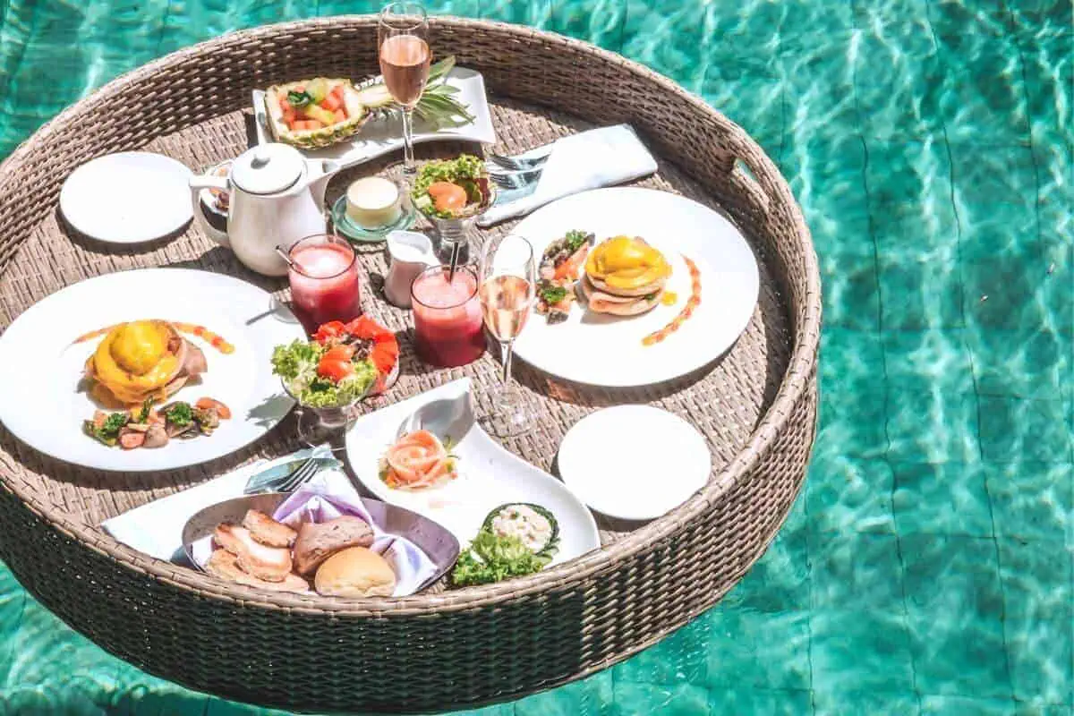 A floating breakfast tray filled with tasty dishes, fruit juice and fizzy wine