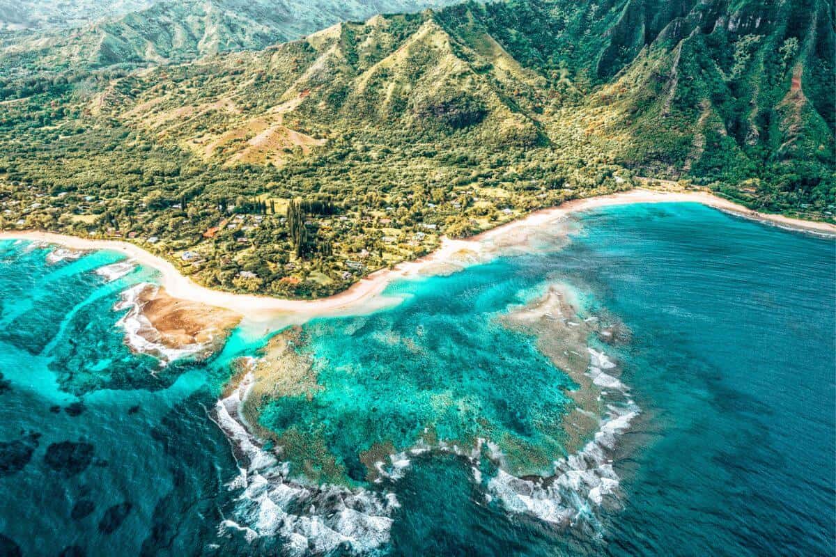 A view across the sea looking towards the lush, mountainous landscape of an island in Hawaii