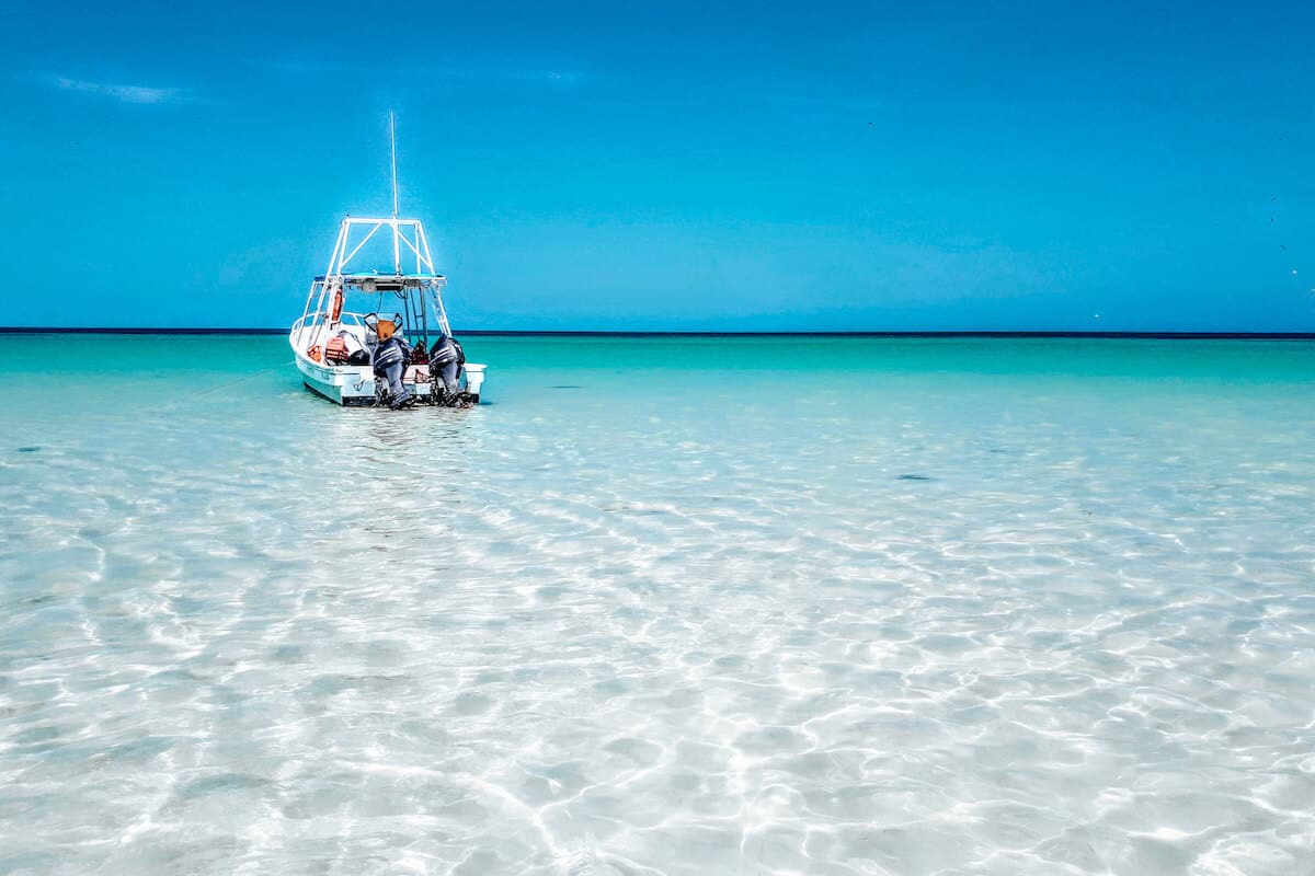 A small boat set in shallow, crystal clear waters in Isla Holbox, Mexico