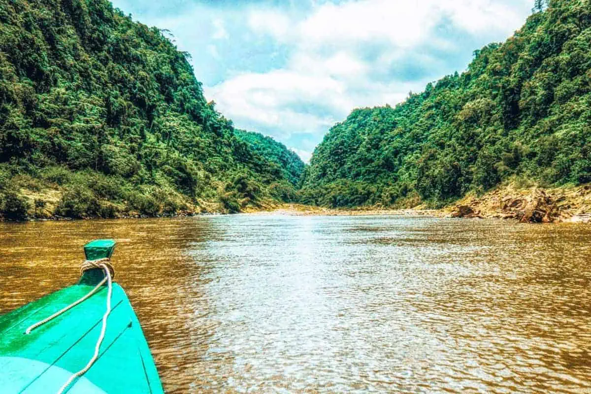 The front of a small boat on a wide, tropical river in Fiji