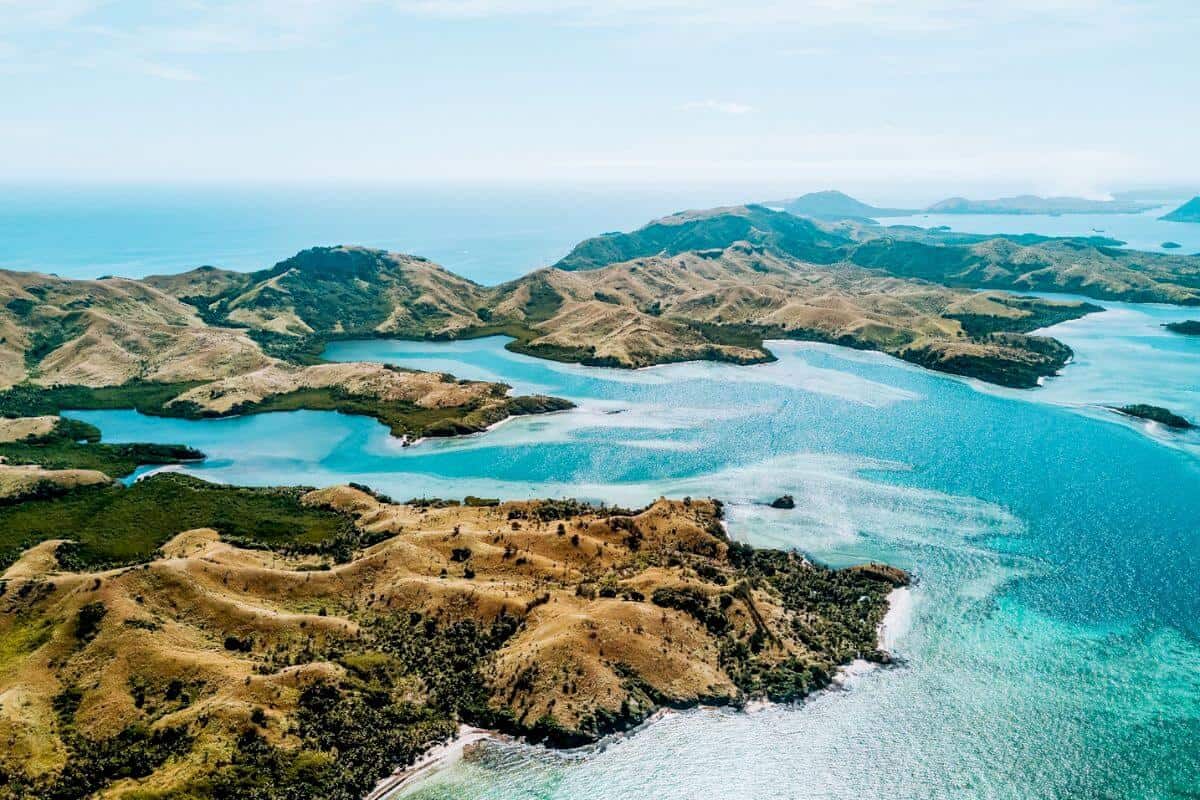 An aerial view of several rugged, tropical islands in turquoise seas in Fiji