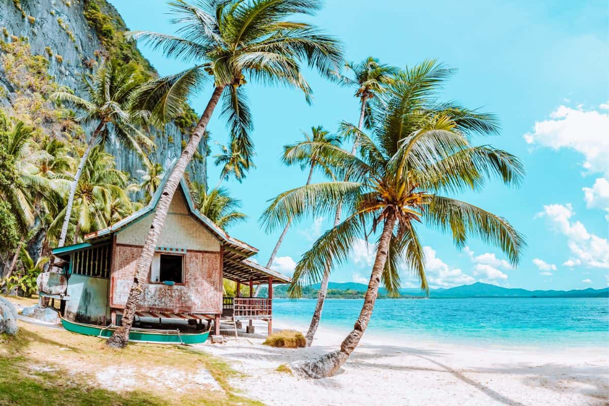A beach hut on a tropical white-sand beach in Palawan, Philippines