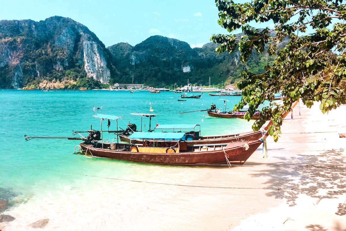 Several traditional longtail boats on a tropical beach in Thailand