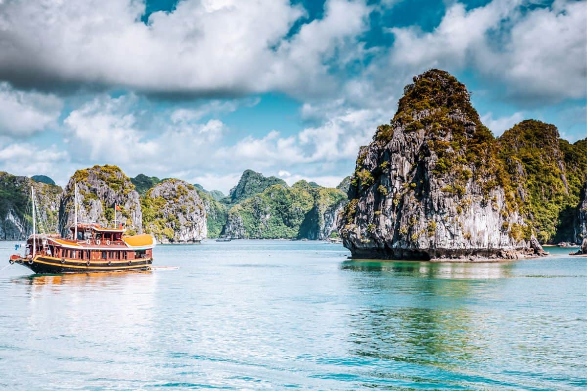 A traditional boat and limestone cliffs in Vietnam's Ha Long Bay
